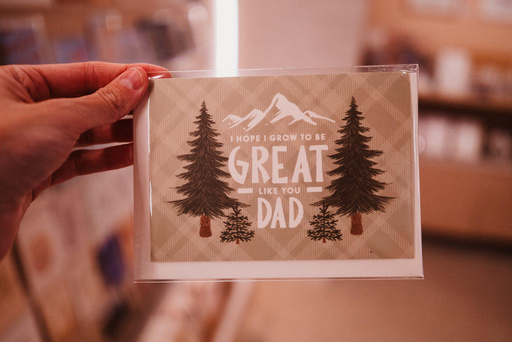 A Father's day card that has pictures of mountains and pine trees on the front, as well as the text 'I hope I can grow to be great like you Dad'.